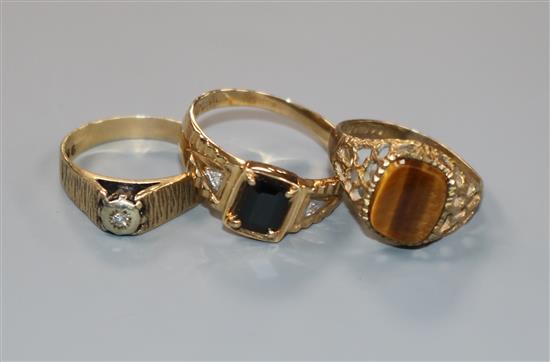 A 9ct gold tigers eye ring, a gem-set 10ct gold ring and a 9ct gold and diamond textured ring.